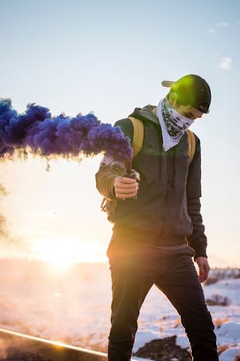 man holding purple flare