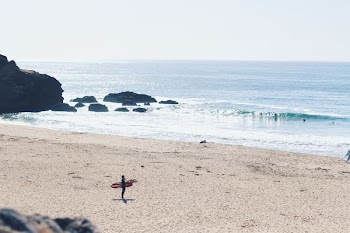 man holding red surfboard on beach