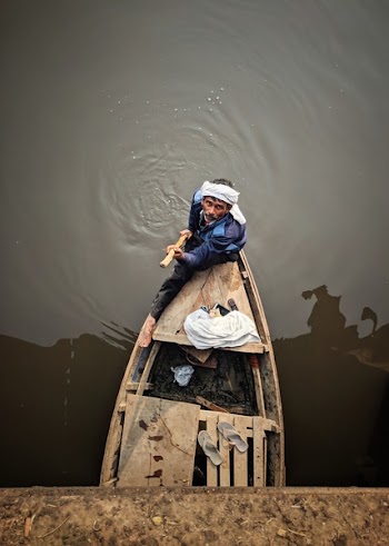 Man Holding Rod While Standing in Boat