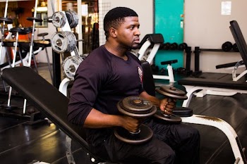 Man Holding Round Black Dumbells