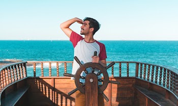 Man Holding Ship's Wheel