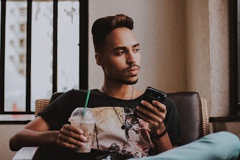 Man Holding Smartphone and Clear Disposable Tumbler