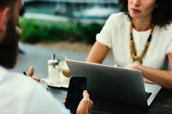 man holding smartphone in front of woman