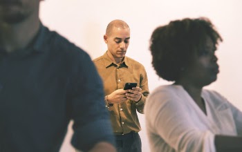 Man Holding Smartphone Near Wall