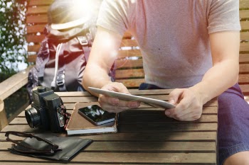 Man Holding Tablet Computer While Sitting on Bench