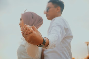 Man Holding the Hand of the Woman