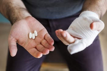 Man Holding Three White Medication Pills