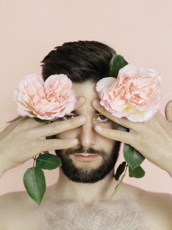 Man Holding Two Pink Flowers
