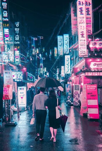 man holding umbrella beside woman while walking on street