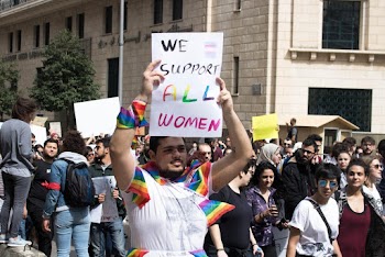 Man Holding We Support All Women Signage