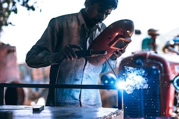 man holding welding rod and mask