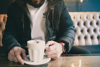 Man Holding White Ceramic Mug While Sitting on Couch