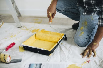 Man Holding Yellow Paint Roller