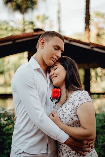 Man Hugging Woman Holding Rose