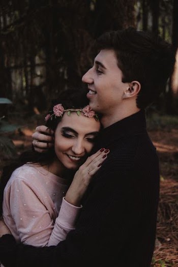 man hugging woman while smiling at daytime