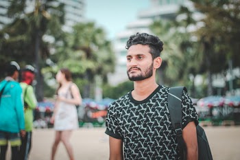 Man in Black and White Crew-neck Shirt Wearing Black Backpack