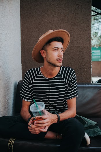 Man In Black And White Stripe Shirt Holding Cup 