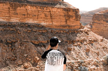 Man in Black and White Top in Front of Mountain