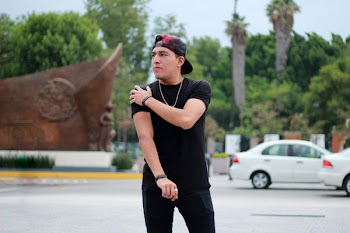 Man in Black Cap and Shirt Standing Near Cars