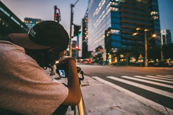 Man in Black Cap Holding Railings
