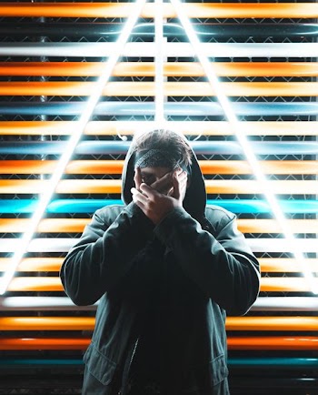 man in black coat standing in front of neon signage