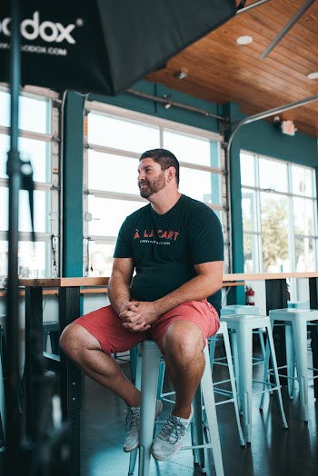 Man in Black Crew-neck T-shirt Sitting on White Steel Bar Chair