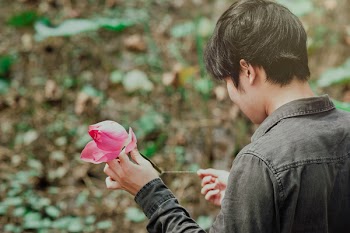 Man in Black Denim Jean Holding Pink Flower