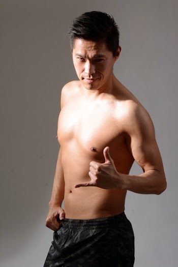 Man in Black Drawstring Bottoms Standing Against Gray Wall