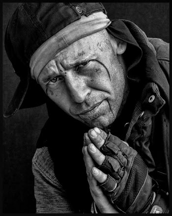 Man in Black Hat Gloves and Jacket Holding Hands Together Greyscale Photo