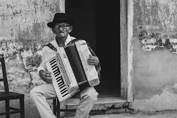 Man in Black Hat Playing An Accordion