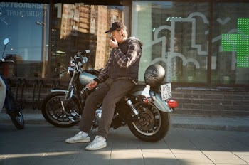 Man in Black Hooded Jacket Sitting on Motorcycle