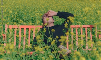 Man in Black Hoodie Sitting on Red Bench