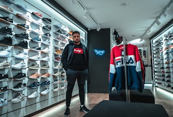 Man in Black Jacket and Black Jogger Pants Standing Inside A Store