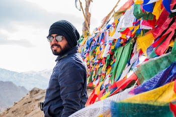 Man in Black Jacket and Knit Cap Standing in Front of Assorted-color Paper Lot