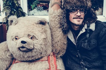 Man in Black Jacket Beside Bear Mascot