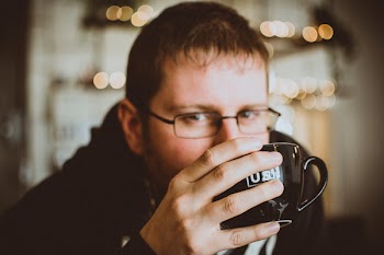 Man in Black Jacket Holding a Mug