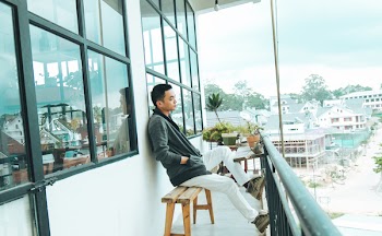 Man in Black Jacket Sitting on Bench Outdoors