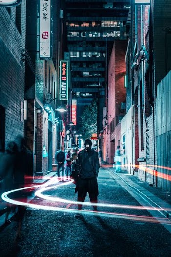 man in black jacket standing in middle of street