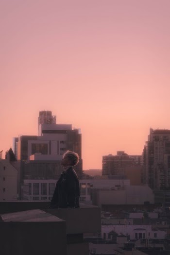Man in Black Jacket Standing on Top of Building during Sunset · Free Stock Photo