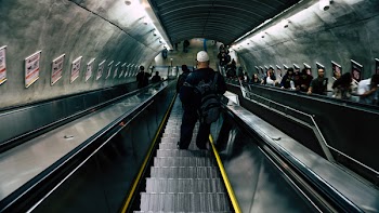 Man in Black Leather Jacket on Escalator