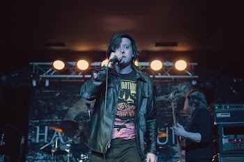 man in black leather jacket singing with microphone