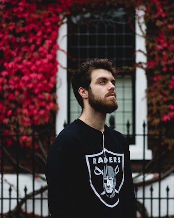 man in black Oakland Raiders long-sleeved shirt