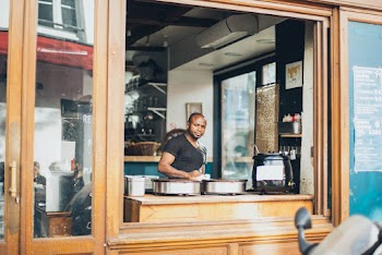 Man in Black Scoop-neck T-shirt Standing Near Wooden Table