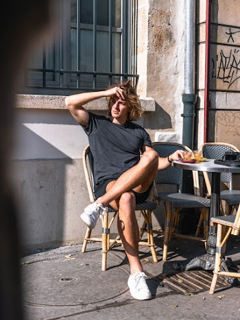Man in Black Shirt and Shorts Sitting Outside