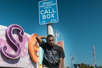 Man in Black Shirt Beside Road Sign