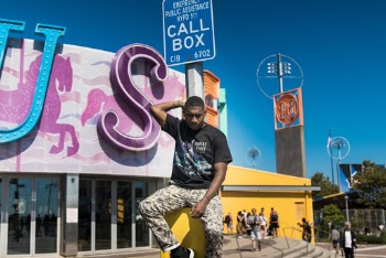 Man in Black Shirt Sitting On A Post