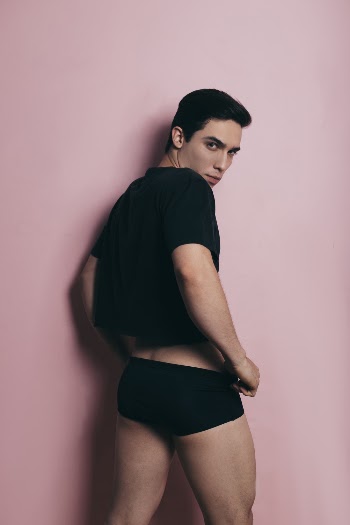 Man In Black Shirt Standing In Front Of Pink Wall