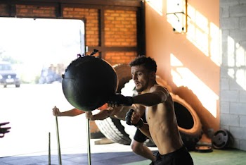 Man in Black Shorts Punching Black Ball