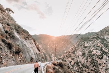 man in black shorts walking on gray road