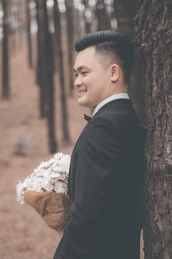 Man in Black Suit Holding Flowers